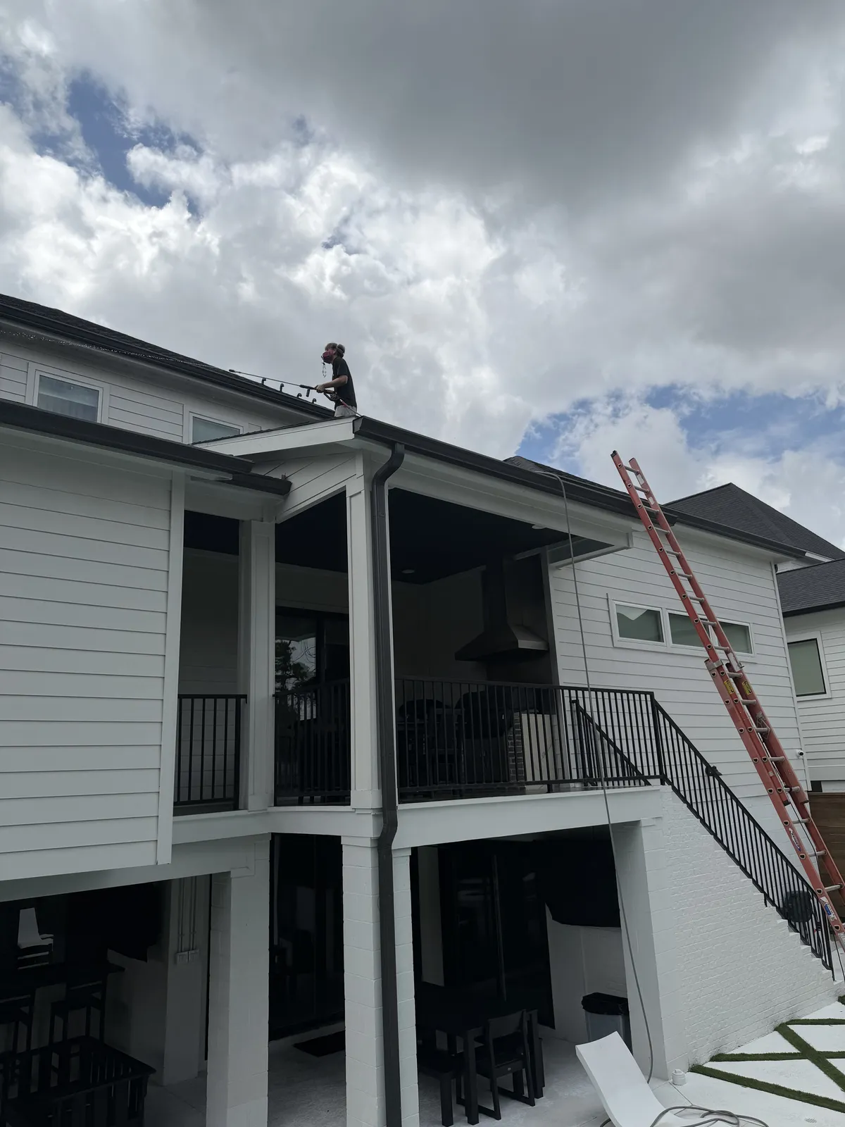 Crew member working along the roofline of a two-story Houston home
